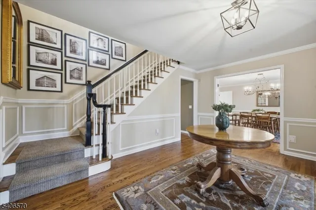 a dining room with wooden floor and a chandelier