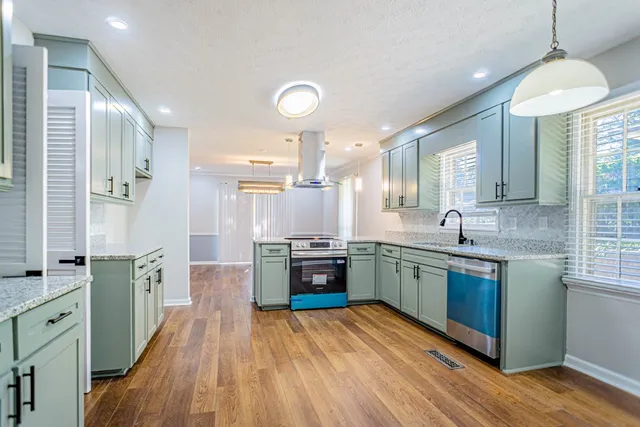 a kitchen with stainless steel appliances granite countertop wooden floors and sink