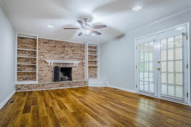 a view of empty room with wooden floor and fireplace