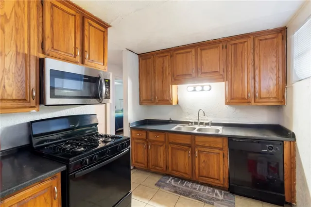 a kitchen with stainless steel appliances a stove a sink and a microwave
