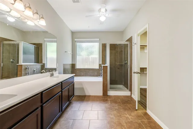 a bathroom with a double vanity sink a mirror and a bathtub