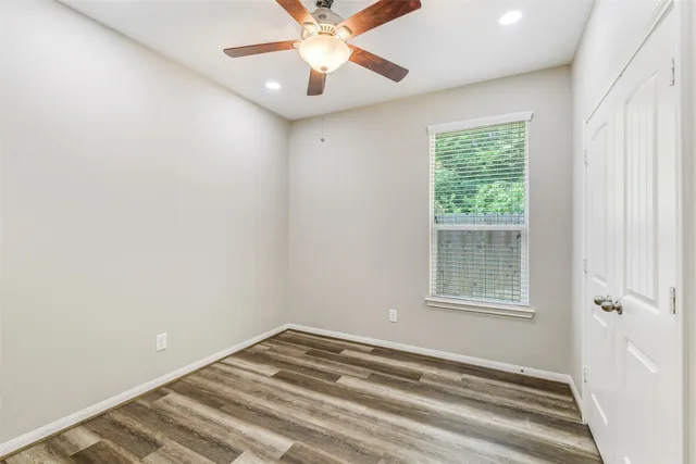 an empty room with a window and a fan