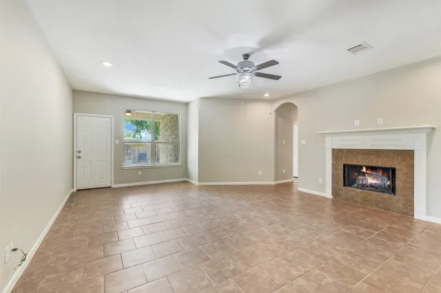 an empty room with windows and fireplace