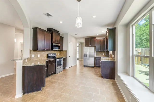 a large kitchen with a large counter top appliances and cabinets