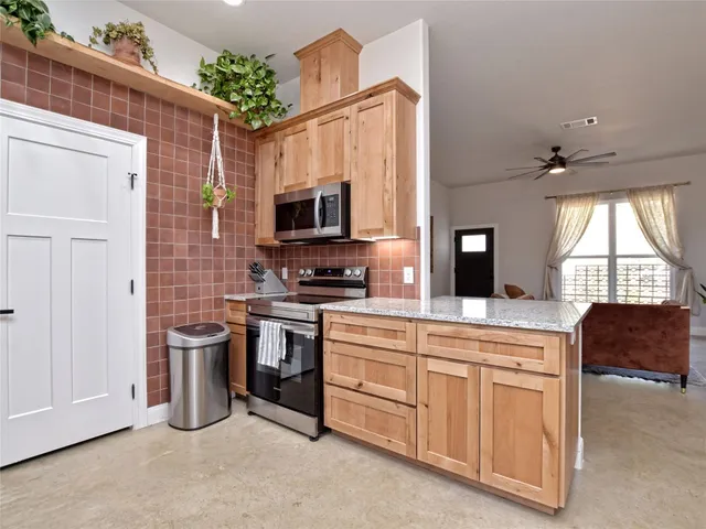 a kitchen with stainless steel appliances a stove a sink and a refrigerator