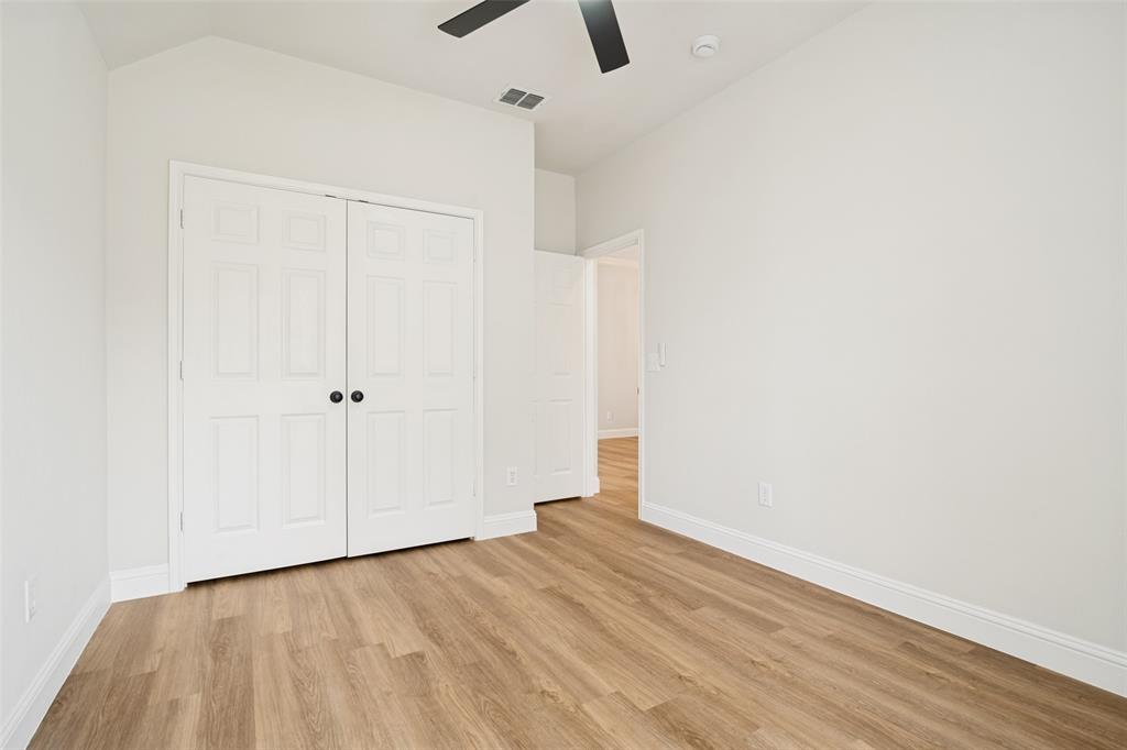 3020 Ridge Hollow Drive Plano, TX 75023 - Photo 14 of 28 Interior room with wood-finish flooring, white baseboards, and a white six-panel bi-fold closet door with black hardware