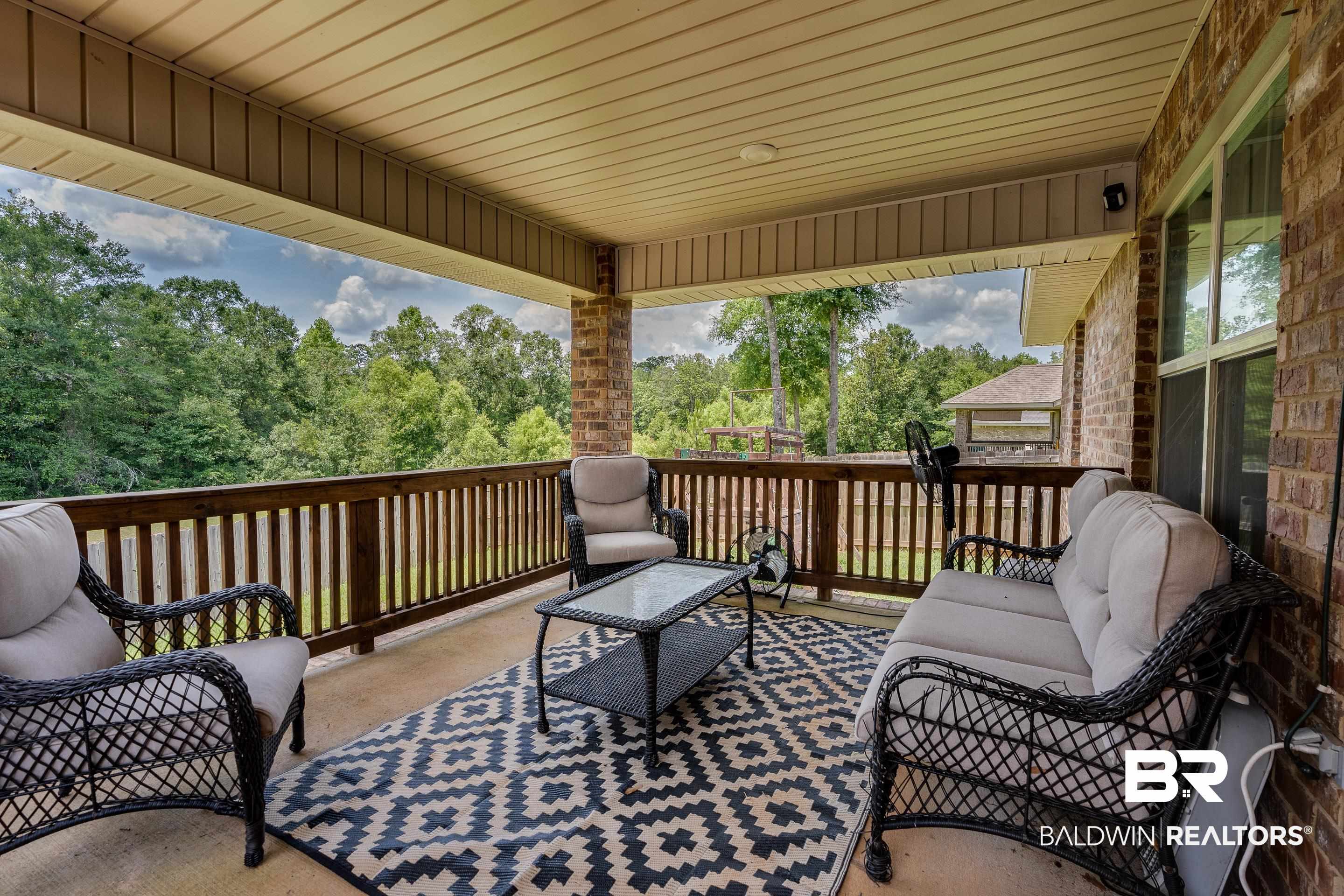2215 Fernwood Loop West Semmes, AL 36575 - Photo 24 of 40 Spacious covered patio featuring a wood railing, brick exterior wall, and a slatted ceiling