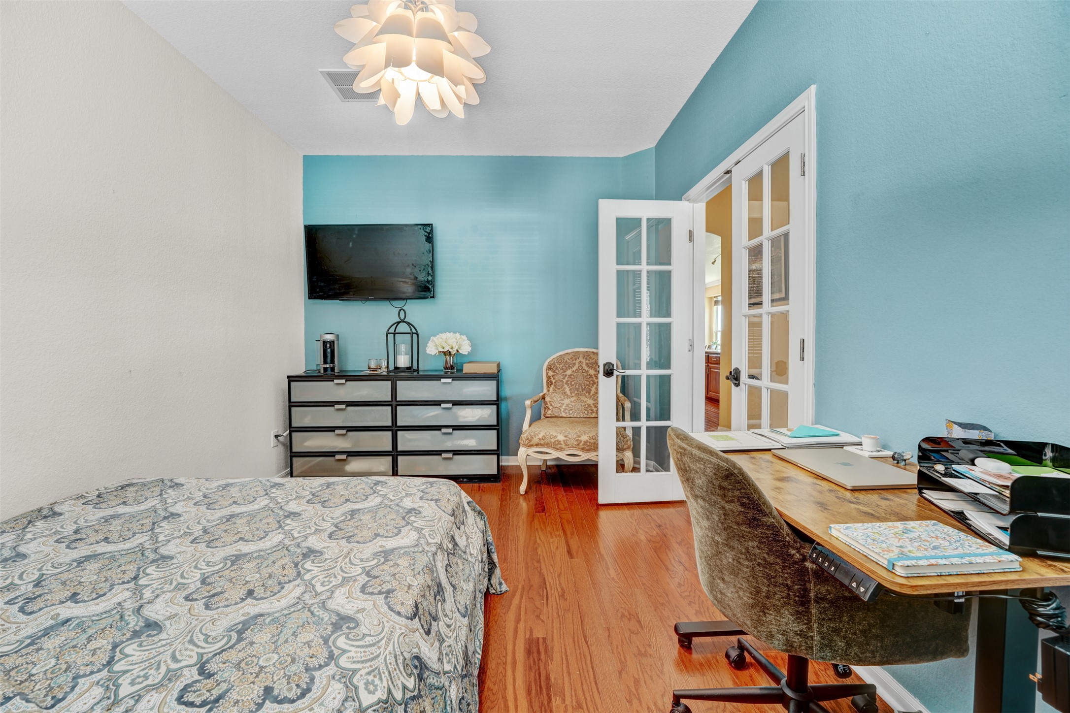 2521 Amen Corner Road Pflugerville, TX 78660 - Photo 29 of 40 Room with hardwood flooring, a contemporary ceiling light fixture, and a built-in wall-mounted television