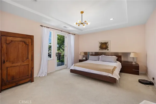 a spacious bedroom with a bed and a chandelier