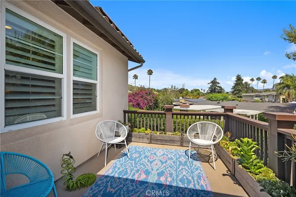 a roof deck with couches and potted plants