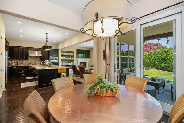 a dining room with furniture a floor to ceiling window and wooden floor