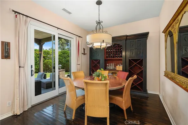 a dining room with furniture a chandelier and wooden floor