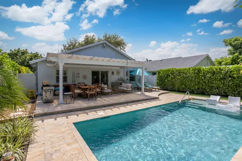 a view of a patio with table and chairs potted plants and a large tree