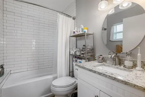 a bathroom with a granite countertop sink toilet and shower