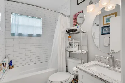 a bathroom with a granite countertop sink mirror vanity and toilet