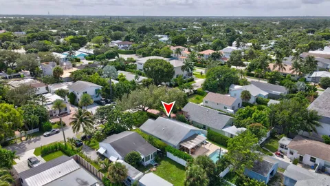 an aerial view of residential houses with outdoor space and trees