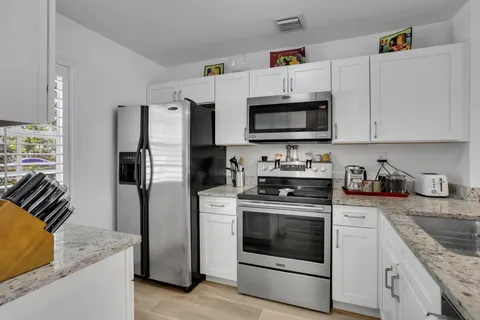 a kitchen with stainless steel appliances granite countertop a stove a refrigerator and a sink