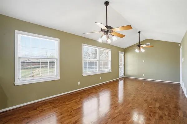 a kitchen with kitchen island granite countertop a stove a sink dishwasher and wooden cabinets with wooden floor