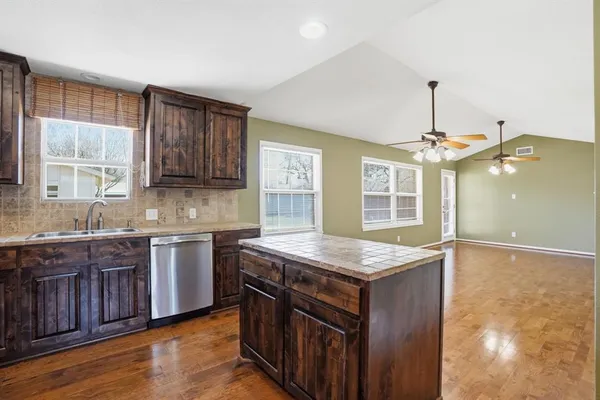 a kitchen with a refrigerator a sink and wooden cabinets