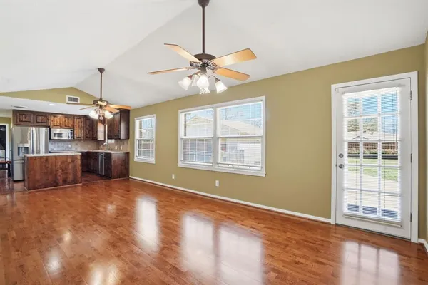 a view of a kitchen with furniture wooden floor and a ceiling fan