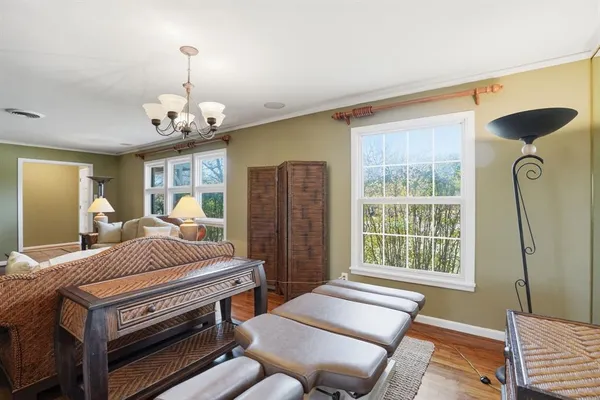 a living room with furniture a chandelier and a window