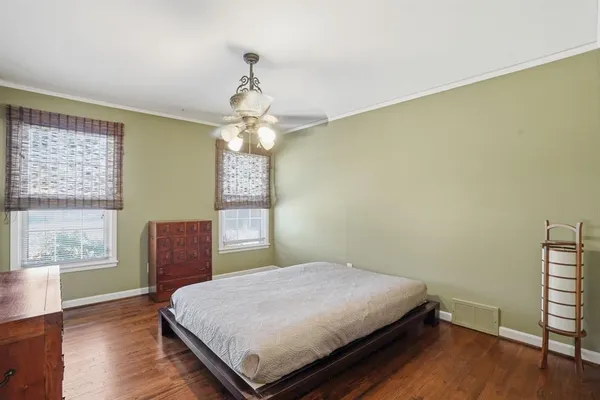 a bed sitting in a spacious bedroom next to a window