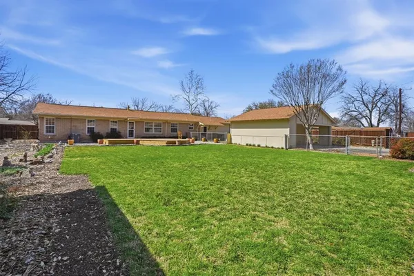 a view of a house with a big yard and large trees