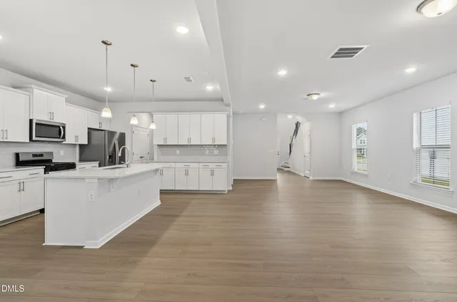 a view of kitchen with cabinets microwave and stove
