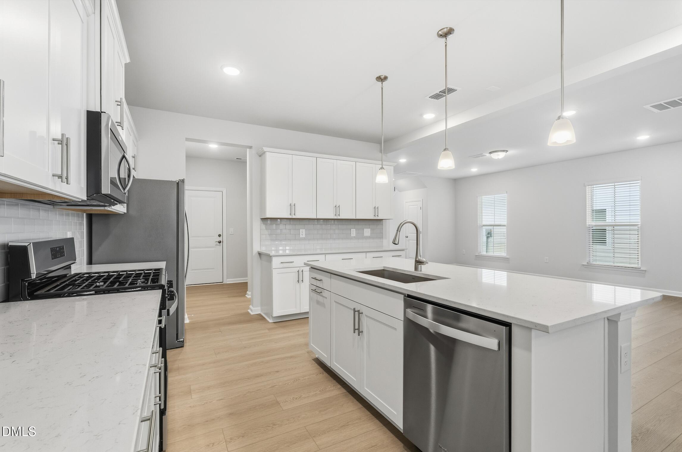 505 Providence Springs Lane Fuquay-Varina, NC 27526 - Photo 14 of 40 a kitchen with a sink a center island stainless steel appliances and cabinets