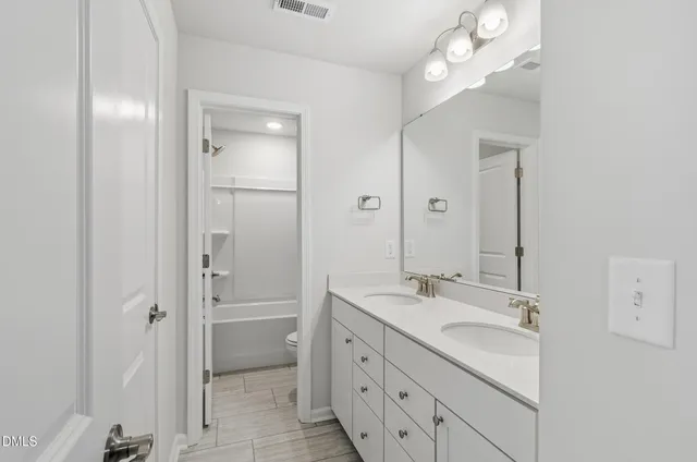 a bathroom with a granite countertop sink a mirror and a shower