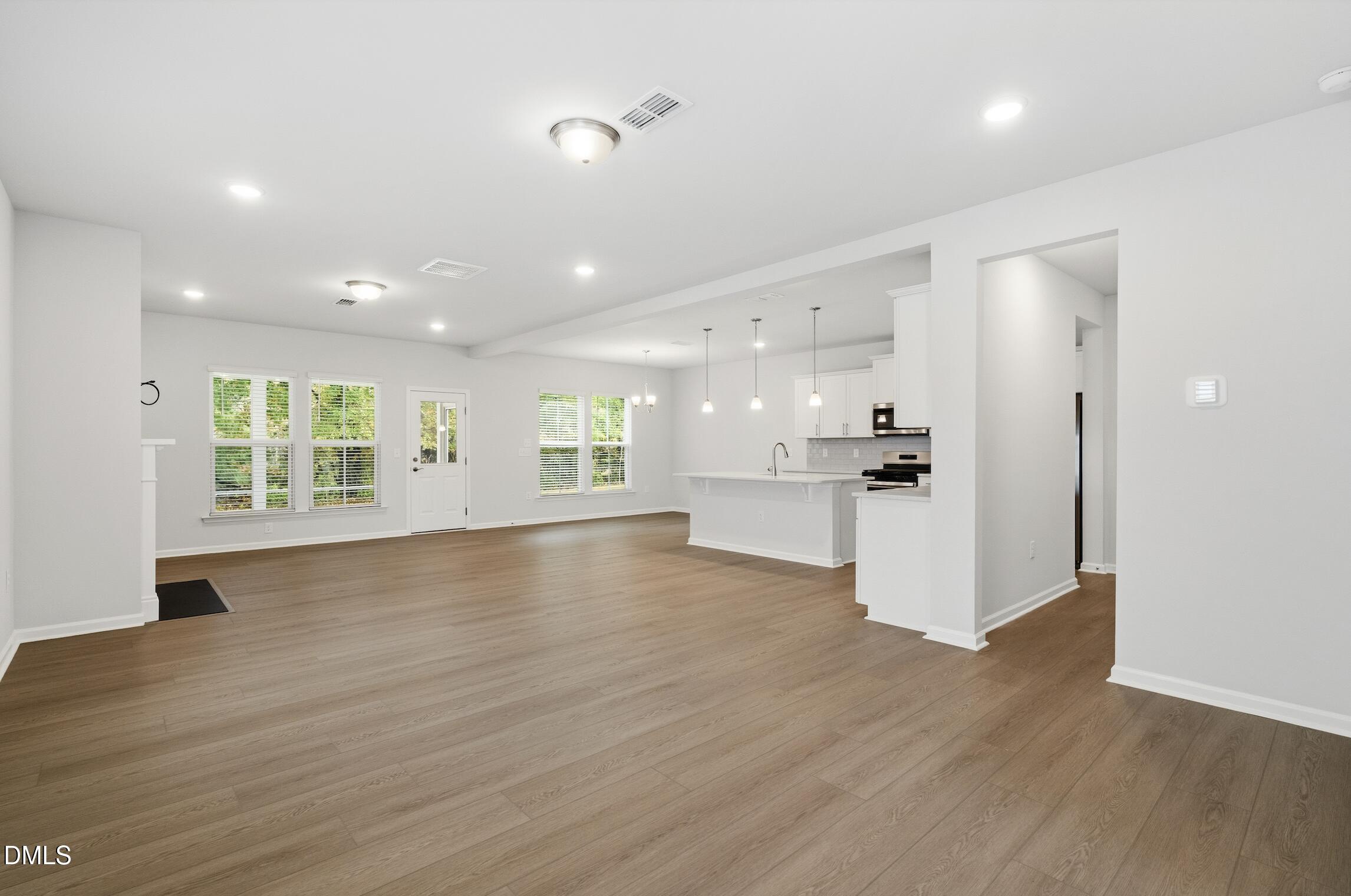 505 Providence Springs Lane Fuquay-Varina, NC 27526 - Photo 7 of 40 a view of an empty room with wooden floor and a window
