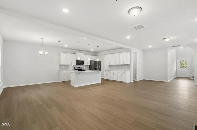 a view of kitchen with kitchen island wooden floor and center island