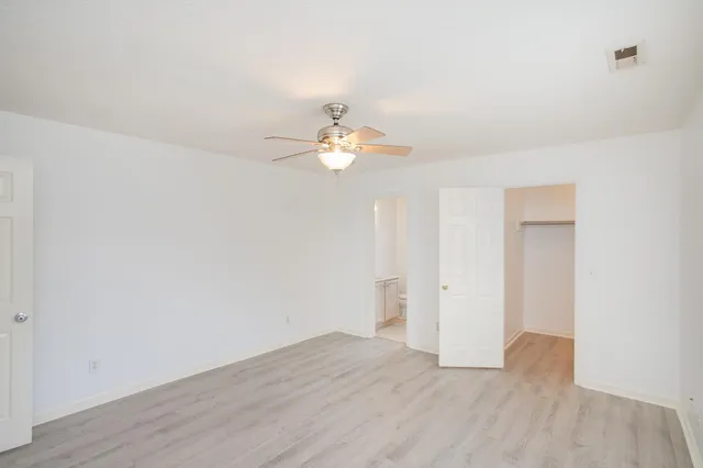 a view of a room with wooden floor and a ceiling fan