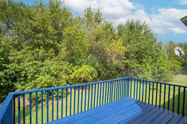 a balcony with wooden floor and fence