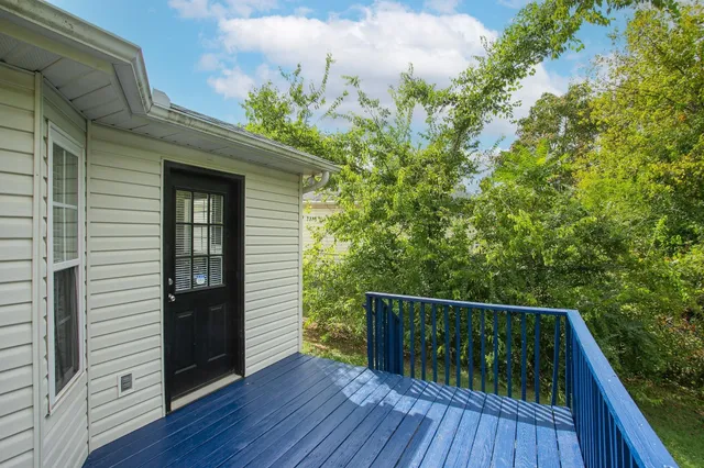 a balcony with wooden floor and bench
