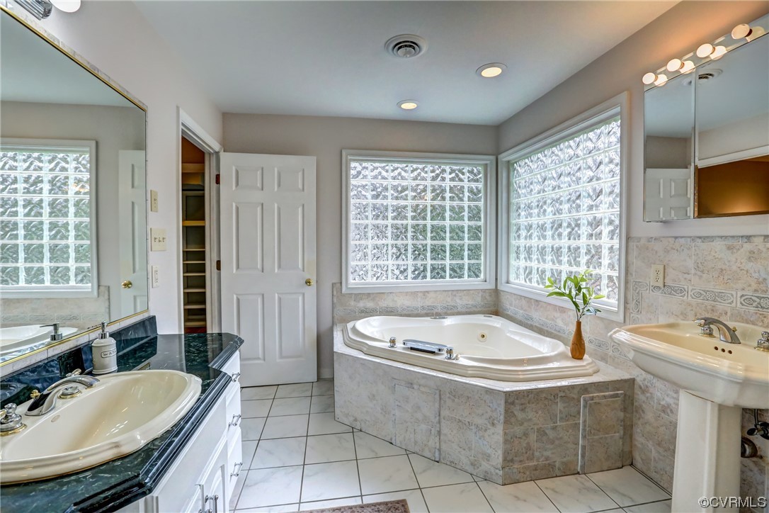 3612 Stoney Ridge Trail Midlothian, VA 23112 - Photo 11 of 49 a bathroom with a tub a sink a mirror and a bathtub next to a window