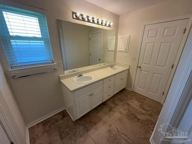 a bathroom with a double vanity sink and a mirror