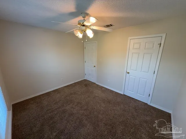 an empty room with a chandelier fan