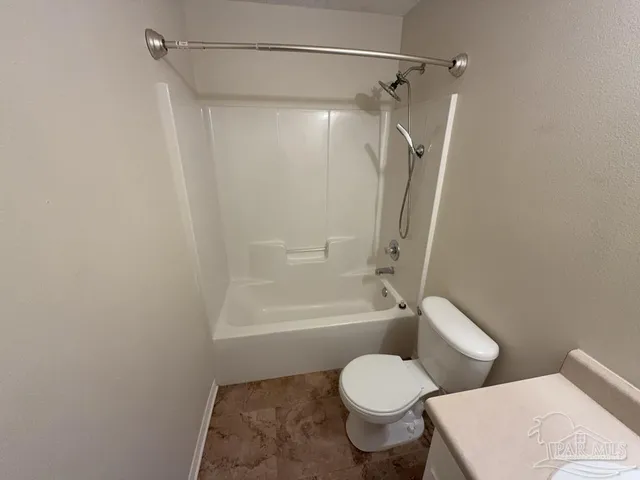 a white toilet sitting next to a bath tub
