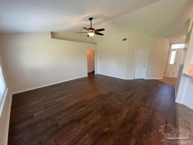 a view of empty room with wooden floor