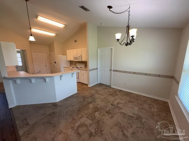a view of a kitchen with a sink and refrigerator