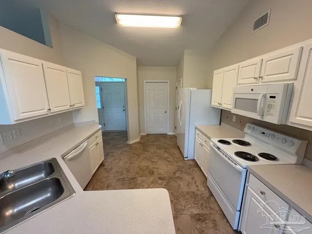 a kitchen with white cabinets and white appliances
