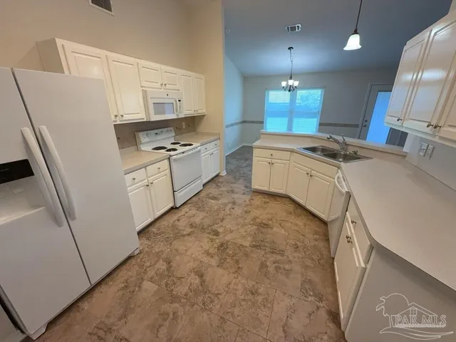 a large kitchen with granite countertop a sink a stove a refrigerator and a stove