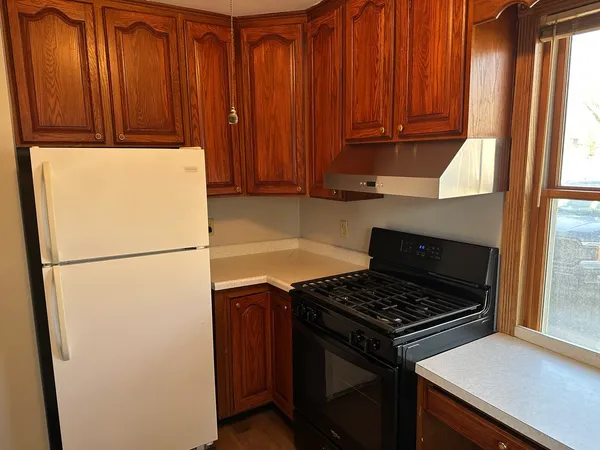 a kitchen with a refrigerator and a stove top oven