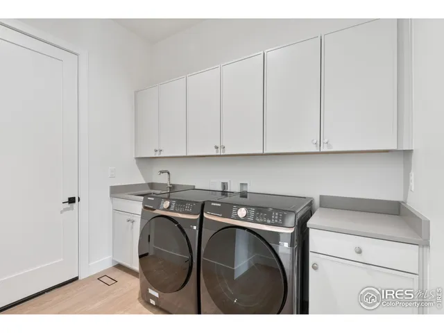 a utility room with cabinets washer and dryer