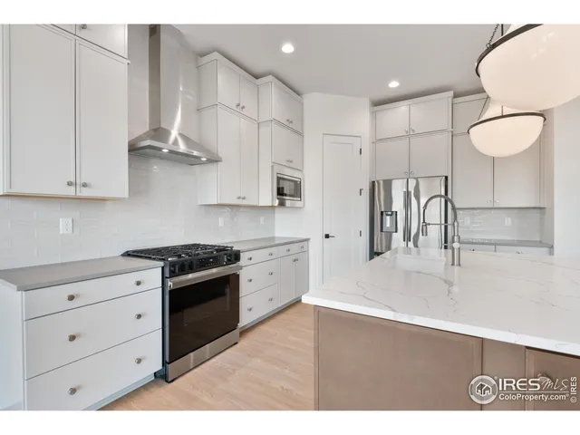 a kitchen with stainless steel appliances granite countertop a sink a stove and a refrigerator