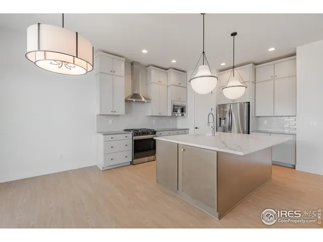 a large kitchen with kitchen island a stove a sink a center island and a cabinets