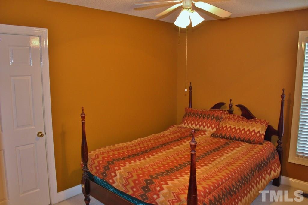 9861 Old Middlesex Road Middlesex, NC 27557 - Photo 9 of 10 a bedroom with a bed and a chandelier