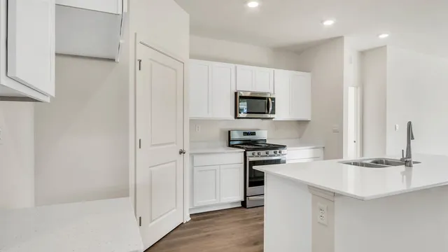 a kitchen with a sink a stove cabinets and refrigerator