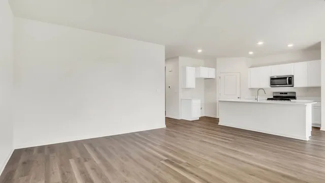 a view of kitchen with wooden floor and electronic appliances